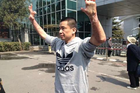 Chang Linfeng showed his hands to the media outside a Beijing courthouse on March 20, 2013, when he was acquitted.　