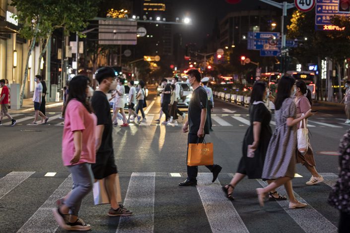 Pedestrians cross the famed Nanjing Road shopping street in Shanghai on July 9. Photo: Bloomberg