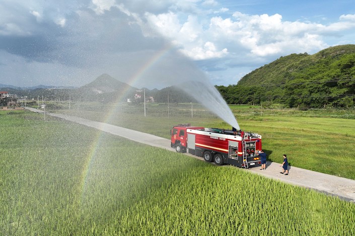 Firefighters help farmers irrigate their rice crop in Yongzhou, Hunan province, on Aug. 23, 2022.