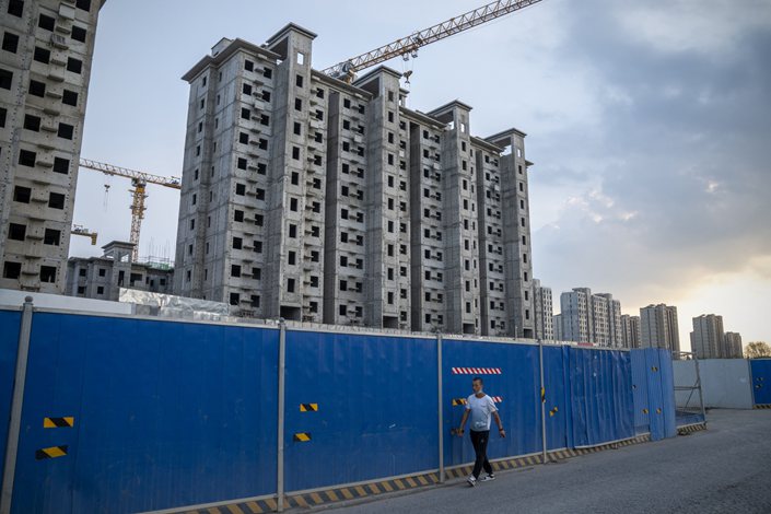 A man walks past the China Evergrande Group Royal Peak residential development under construction in Beijing on July 29. Photo: Bloomberg