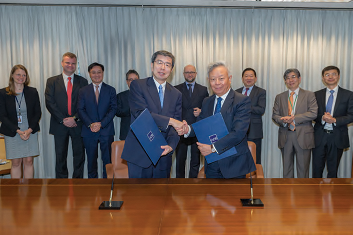 Former ADB President Takehiko Nakao shakes hands with AIIB President Jin Liqun in front of staff in March 2019 at ADB headquarters in Mandaluyong, Philippines. Photo: Courtesy of ADB