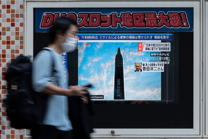 A man in Tokyo on Oct. 4 walks past a TV showing a broadcast about an early morning North Korean missile launch, which prompted an evacuation alert over northeastern Japan.  Photo: VCG