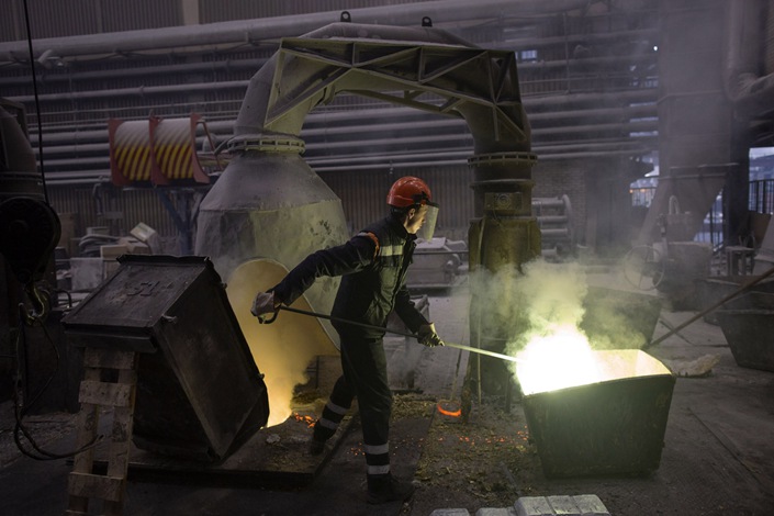 A worker uses a rod to stir a mixture of molten copper and zinc in the foundry of a copper plant in Sevojno, Serbia, on Oct. 26, 2021. Photo: Bloomberg