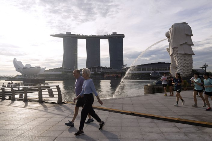 Groups of people exercise by the Merlion Park and Marina Bay Sands in Singapore on Oct. 8. Photo: Bloomberg