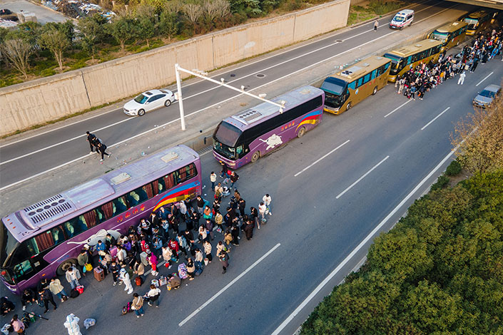 Some Foxconn employees get on buses to return home in Zhengzhou, Central China’s Henan province, on Sunday. Photo: VCG
