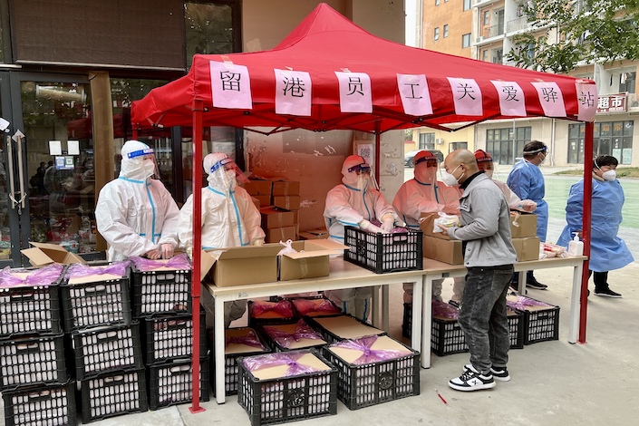 Supplies are handed out to employees at Foxconn’s Zhengzhou factory Nov. 3, 2022.