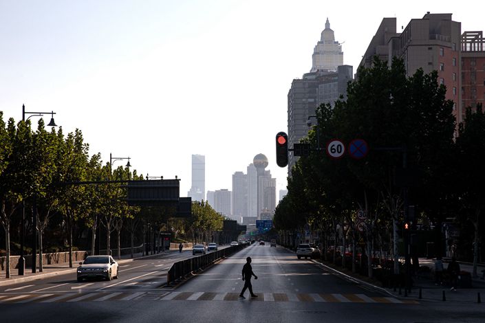A resident crosses a nearly deserted street on Nov. 2 in Wuhan, Central China’s Hubei province. Photo: Bloomberg