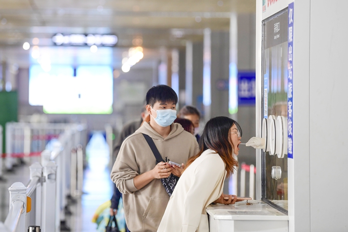 On Nov. 19, in Ganzhou City, Jiangxi Province, at the exit of Ganzhou Railway Station, passengers were taking nucleic acid testing. Photo: VCG