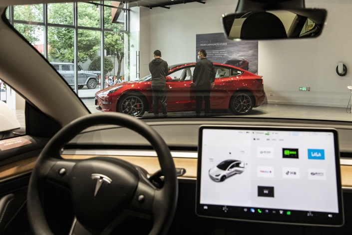 Customers check out a vehicle at a Tesla showroom in Shanghai on Oct. 16. Photo: Bloomberg