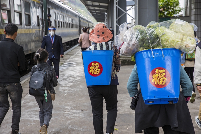On June 13, in Liangshan Yi Autonomous Prefecture, Sichuan province, farmers prepare to take the train. Photo: VCG