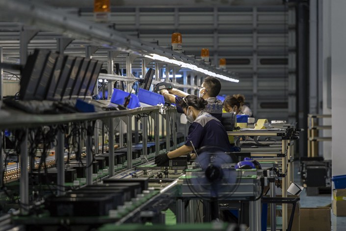 Employee work on an assembly line for refurbished computer consoles at the Sketch Global facility in the Lingang Special Area and Comprehensive Zone in Shanghai on Aug. 25. Photo: Bloomberg