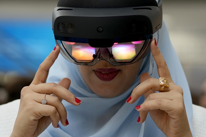 A women tries out virtual reality goggles on Sept. 28 at the Dubai Metaverse Assembly in the United Arab Emirates. Photo: VCG