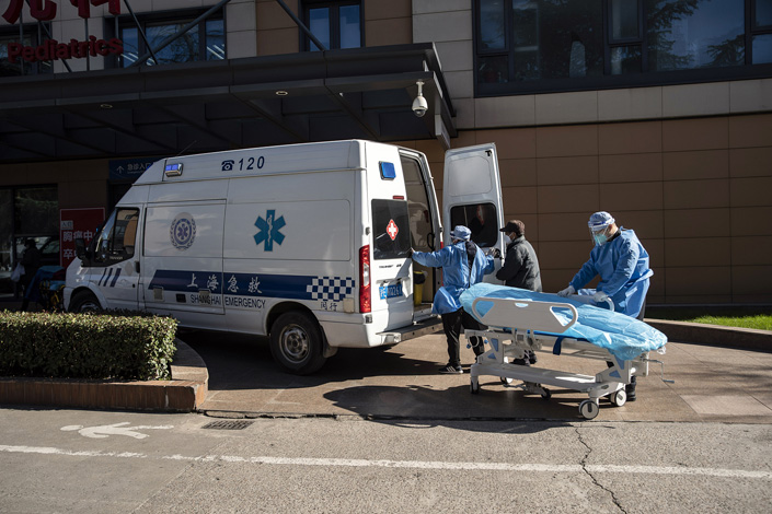 Medical staff transfer a patient outside a hospital’s emergency clinic in Shanghai on Friday. Photo: VCG