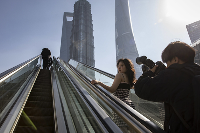 A woman poses for photos in Shanghai’s financial district on Monday. Photo: Bloomberg
