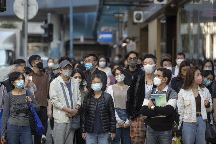 Pedestrians wearing protective face masks in Hong Kong on Dec. 8. Photo: Bloomberg