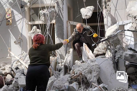 当地时间2023年2月19日，土耳其安塔基亚，破损的楼房内，一名男子试图从中取出生活用品。在土耳其哈塔伊省受灾最严重的地区安塔基亚，当地约有80%的建筑物在地震中损毁。地震发生后，不时有居民返回到安塔基亚城区，从尚未完全倒塌的房屋中抢救出生活用品和财产。图：财新 丁刚 发自土耳其安塔基亚