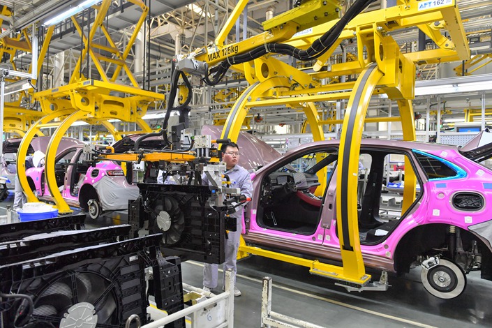 On Feb. 17, workers were manipulating the robot arm to install new energy vehicle parts at the SERES Automobile Factory in Chongqing. Photo: VCG