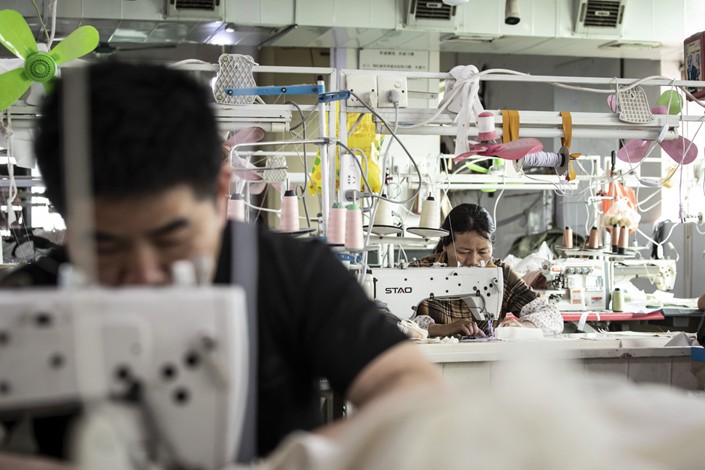 Workers sew clothing on Feb. 9 at a garment factory in Guangzhou, South China’s Guangdong province. Photo: Bloomberg