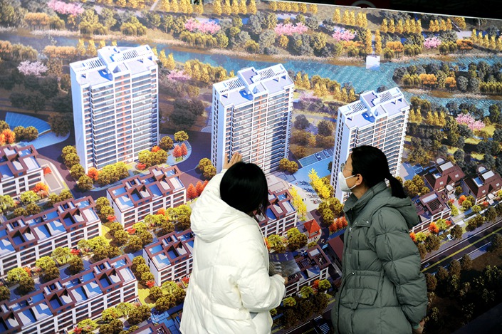 Two women look at an artist impression of a residential property development on Feb. 10 in Weifang, Shandong province. Photo: VCG