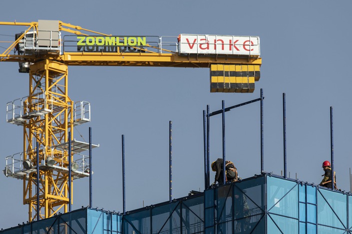 Workers install safety netting at an apartment block under construction in September 2021 in Xining, Northwest China’s Qinghai province. Photo: Bloomberg