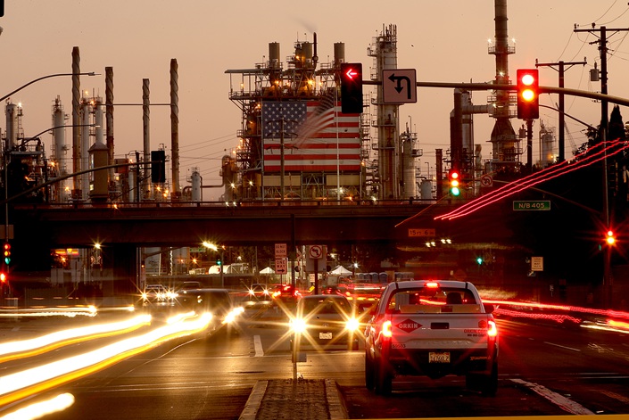 Traffic streams past an oil refinery in the U.S. on Oct. 4. Photo: VCG