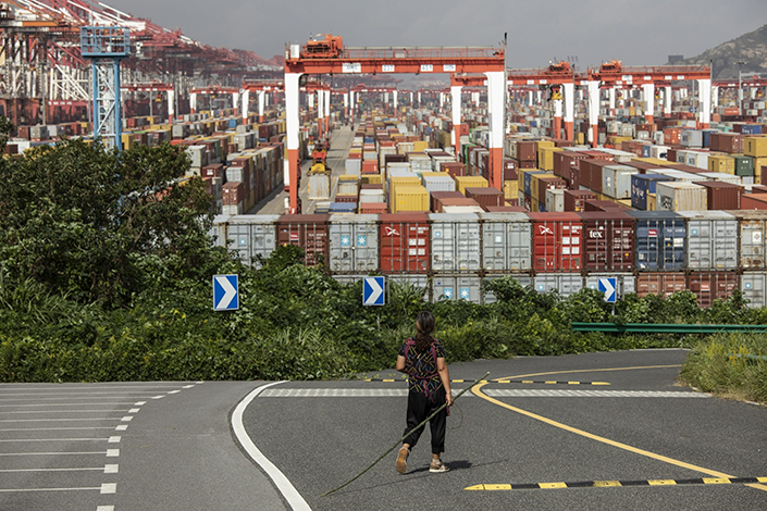 A pedestrian walking by the Yangshan Deepwater Port in Shanghai on Oct. 9, 2021. Photo: Bloomberg