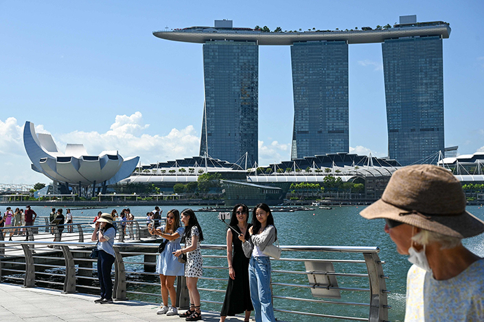 Visitors take photos in front of the Marina Bay Sands resort in Singapore on July 27. Photo: VCG
