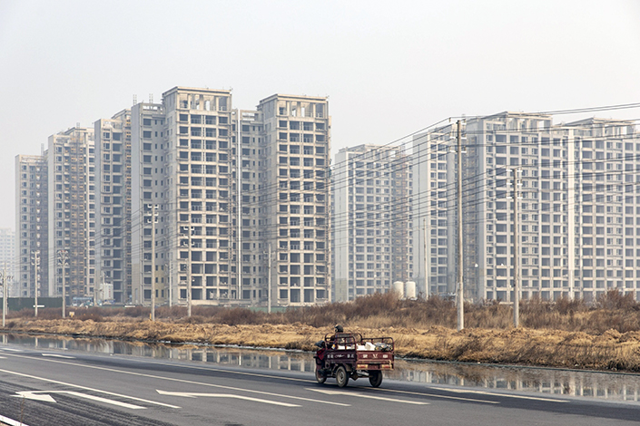 Unfinished residential buildings tower over a road on Jan. 6 in Zhengzhou, Central China’s Henan province. Photo: Bloomberg