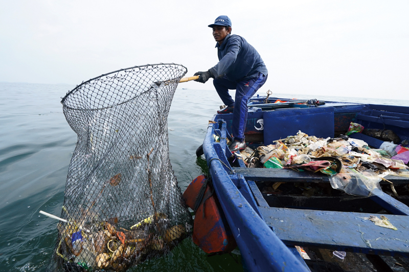 A worker is cleaning plastic garbage from the ocean in Indonesia on Dec. 28, 2022.　