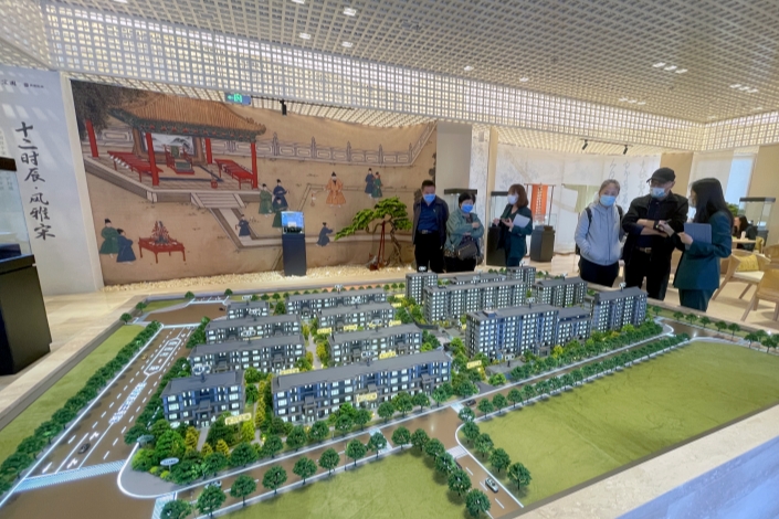 Prospective homebuyers look at a model of a residential development on Oct. 5 in Beijing. Photo: Hou Yu, China News Service/VCG