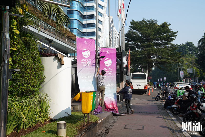 Workers hang posters for the ASEAN Summit in Jakarta, Indonesia on Monday. Photo: Zhang Ruixue/Caixin