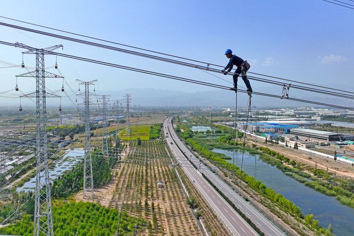Power workers install electrical equipment in Yinchuan, Sept. 11. Photo: VCG