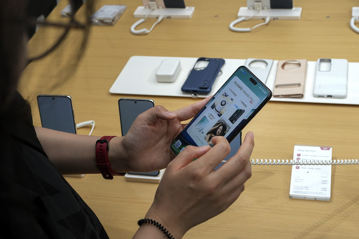 A customer tries out Huawei’s latest smartphone Mate 60 Pro at a Huawei store in Beijing on Sept. 25, 2023.