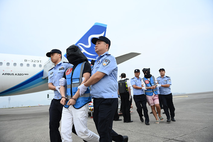 Chongqing police escort suspects in a telecom fraud investigation back to China from Laos on Sept. 11. Photo: Chen Chao/China News Service, VCG