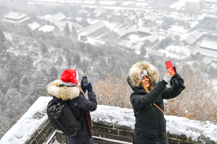 Two tourists take photos of the Great Wall of China in December 2019. Photo: VCG