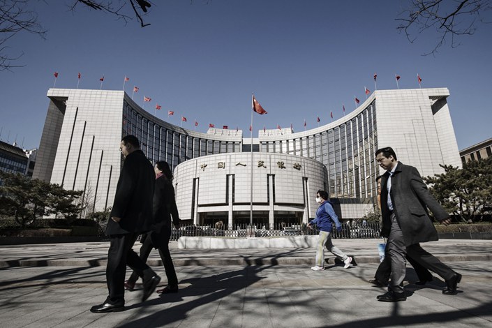 Pedestrians walk past the headquarters of the People's Bank of China in Beijing. Photo: Bloomberg