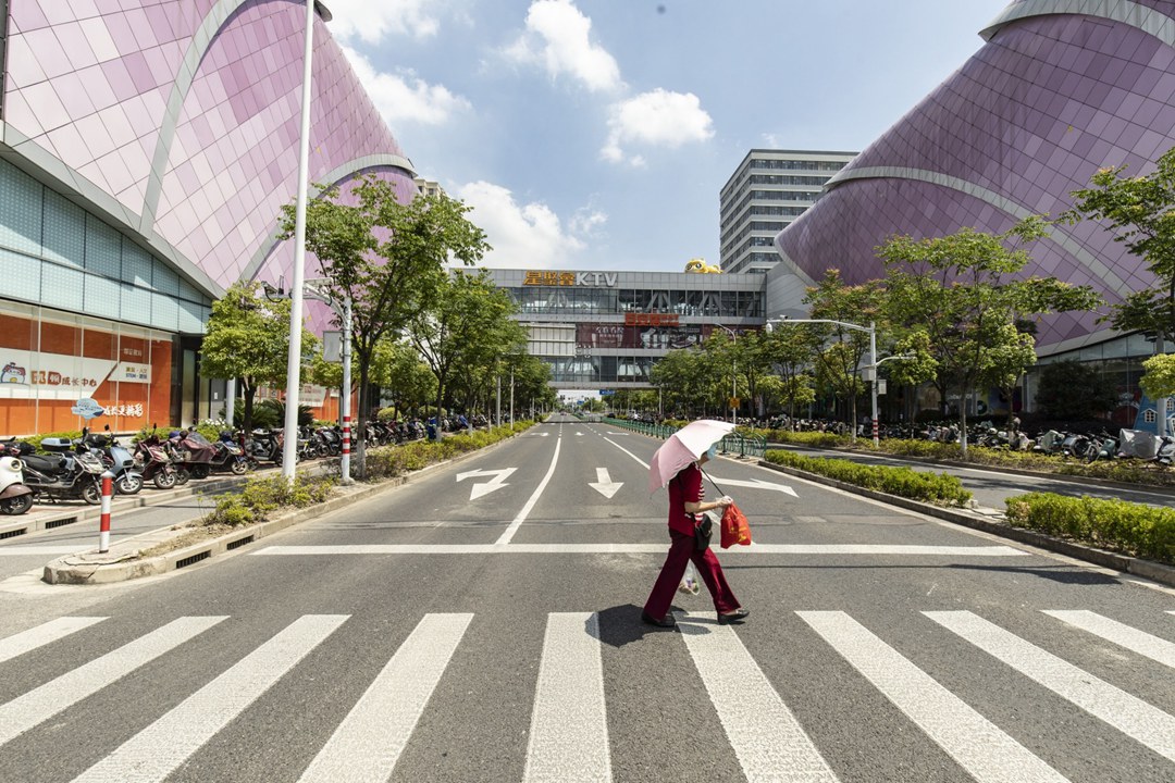 A pedestrian crosses the street outside one of Dalian Wanda Group’s shopping malls in Shanghai on May 25. Photo: Bloomberg