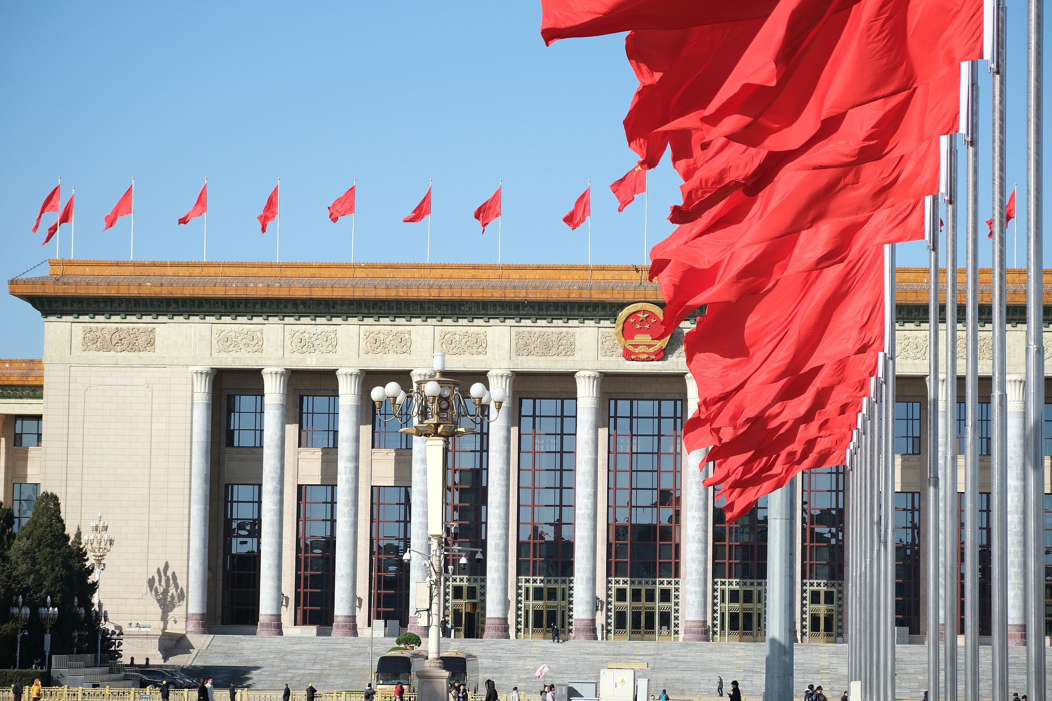 Red flags flutter in the wind outside the Great Hall of the People in Beijing on Sunday. Photo: VCG