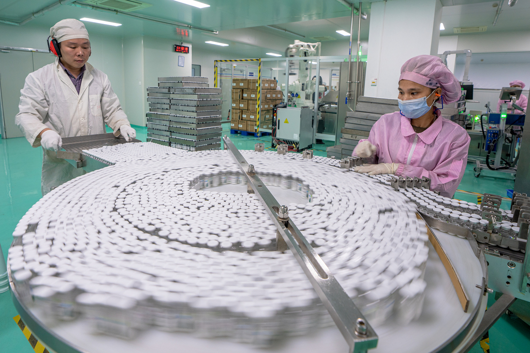 Workers produce a drug at a pharmaceutical factory on Monday. Photo: VCG