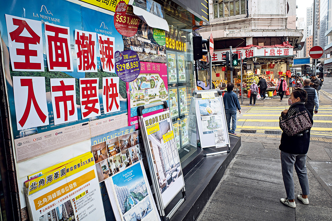 A notice hanging among real estate listings outside a real estate agency on Hong Kong Island announces on Feb. 29 that the city has scrapped its property market restrictions. Photo: VCG