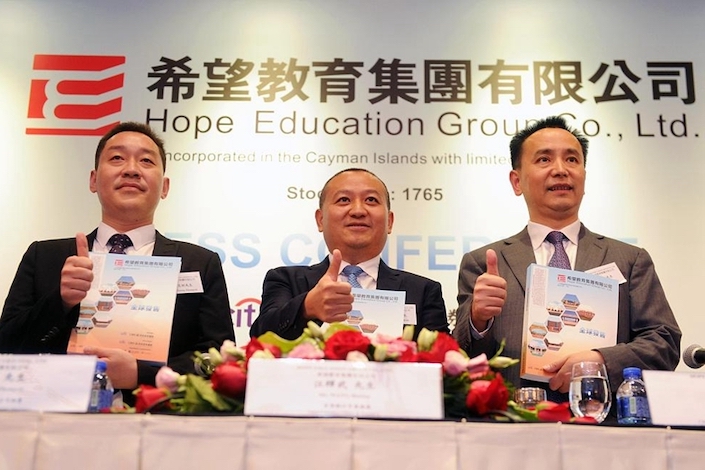 Wang Huiwu (middle), president of XJ International, attends a press conference in Hong Kong on July 23, 2018.