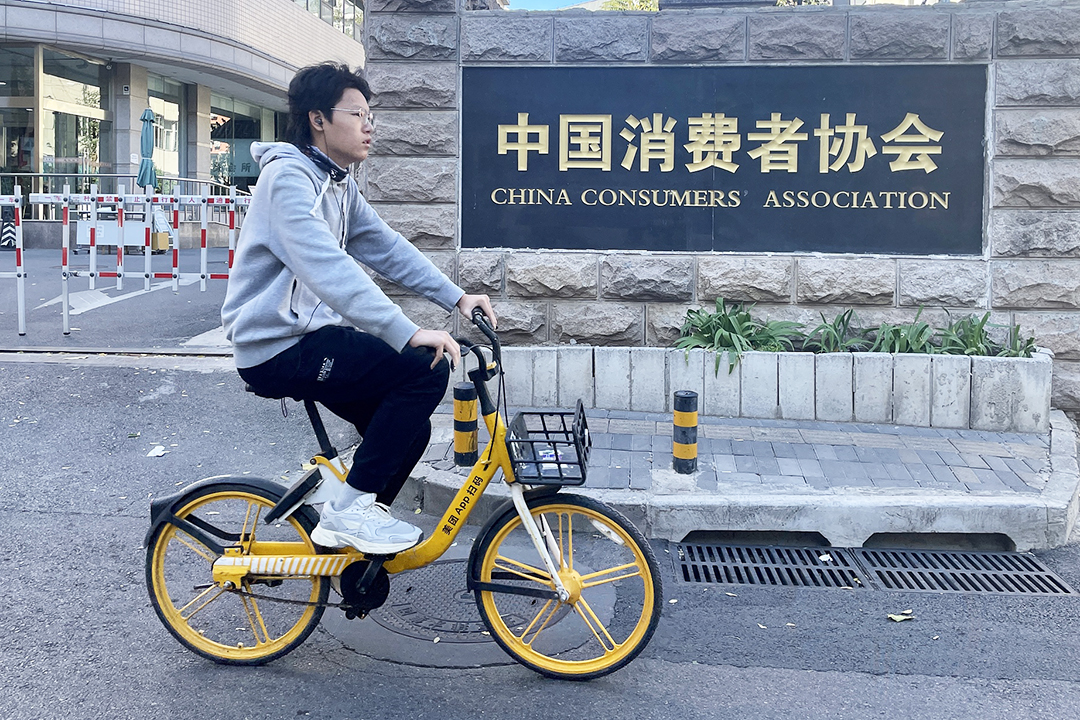 A cyclist rides past the China Consumers Association office in Beijing in October 2022. Photo: VCG