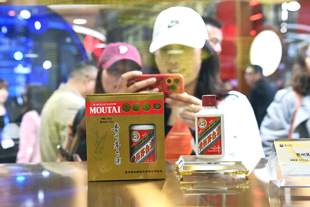 A woman takes a photo of a bottle of Moutai baijiu on March 30 at an industry event in Chengdu, Southwest China’s Sichuan province. Photo: VCG