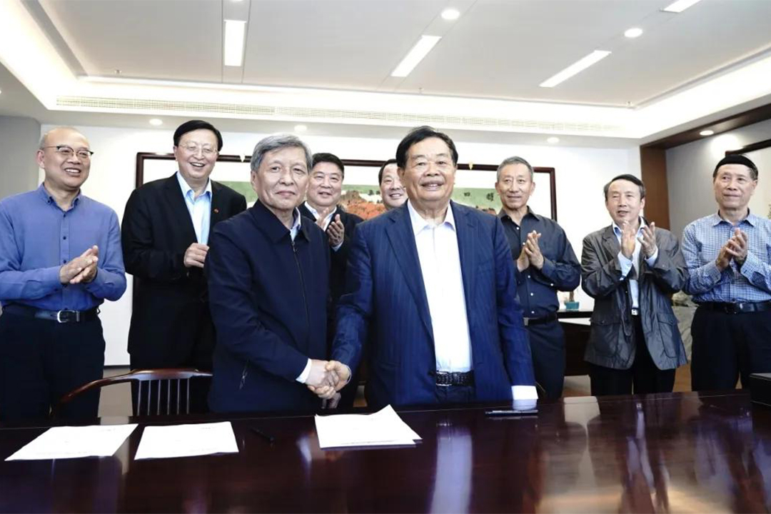 Wang Shuguo (center left) shakes hands with Fuyao University of Science and Technology founder Cao Dewang, the billionaire entrepreneur whose company was featured in the Oscar-winning documentary “American Factory.” Photo: Fuzhou Fuyao Institute of Advanced Study