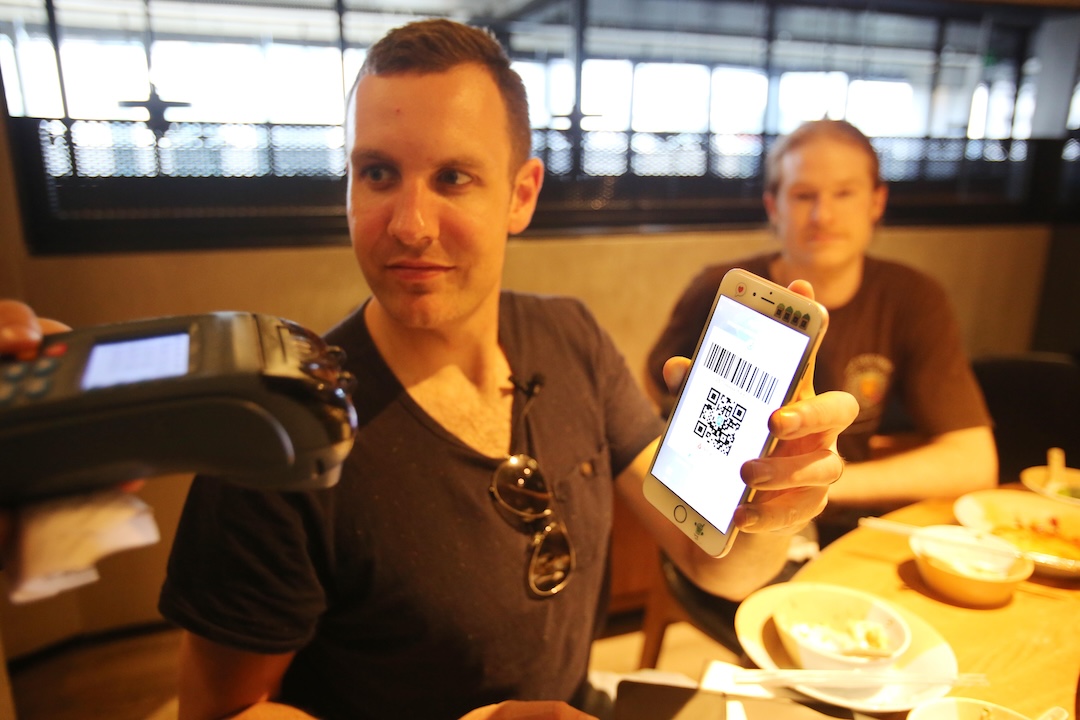 A foreign customer pays the bill at a restaurant with a QR code on his mobile phone in Hangzhou in April 2017. Photo: VCG