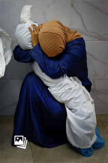 北京时间2024年4月18日，第67届世界新闻摄影大赛（WORLD PRESS PHOTO，即荷赛）公布全球获奖者名单。世界年度新闻图片：《巴勒斯坦妇女拥抱侄女遗体》。当地时间2023年10月17日，加沙汗尤尼斯，医院停尸间内，Inas Abu Maamar抱着她在导弹袭击中遇难的5岁侄女Saly 的遗体。2023年10月7日，在巴勒斯坦激进武装组织哈马斯向以色列发动袭击后，新一轮巴以冲突爆发。截至2024年3月中旬，以军在加沙地带的军事行动已造成3万余人死亡，7万余人受伤。图：Mohammed Salem/WPP