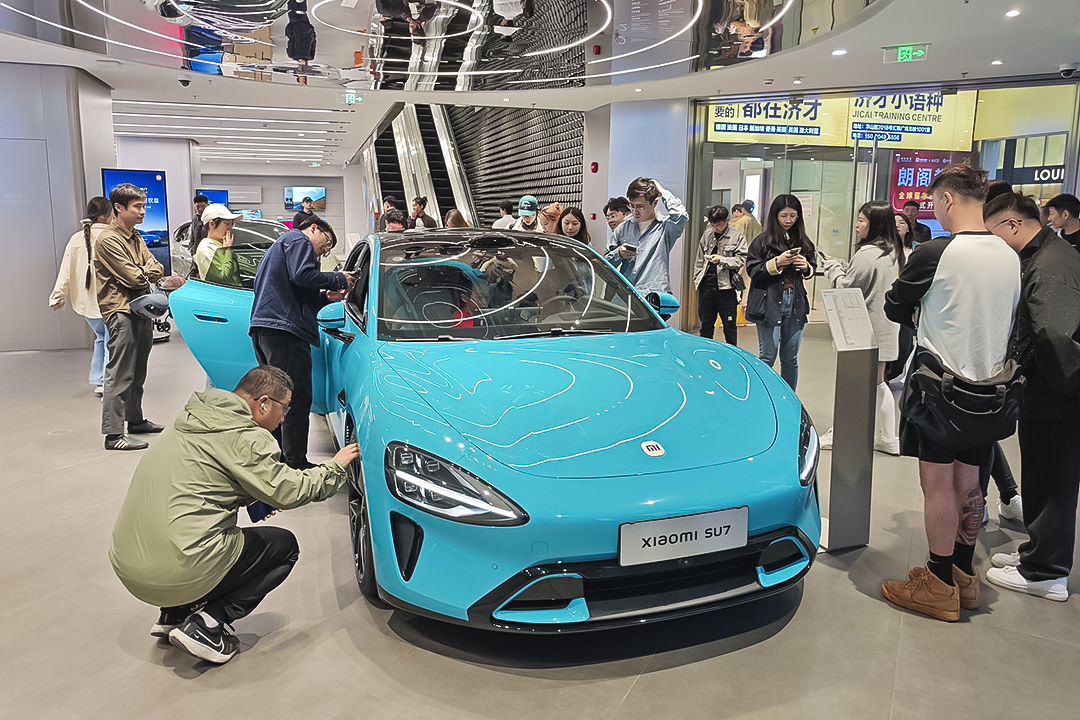 Customers check out at the Xiaomi SU7 electric vehicle in Shanghai on Sunday. Photo: VCG