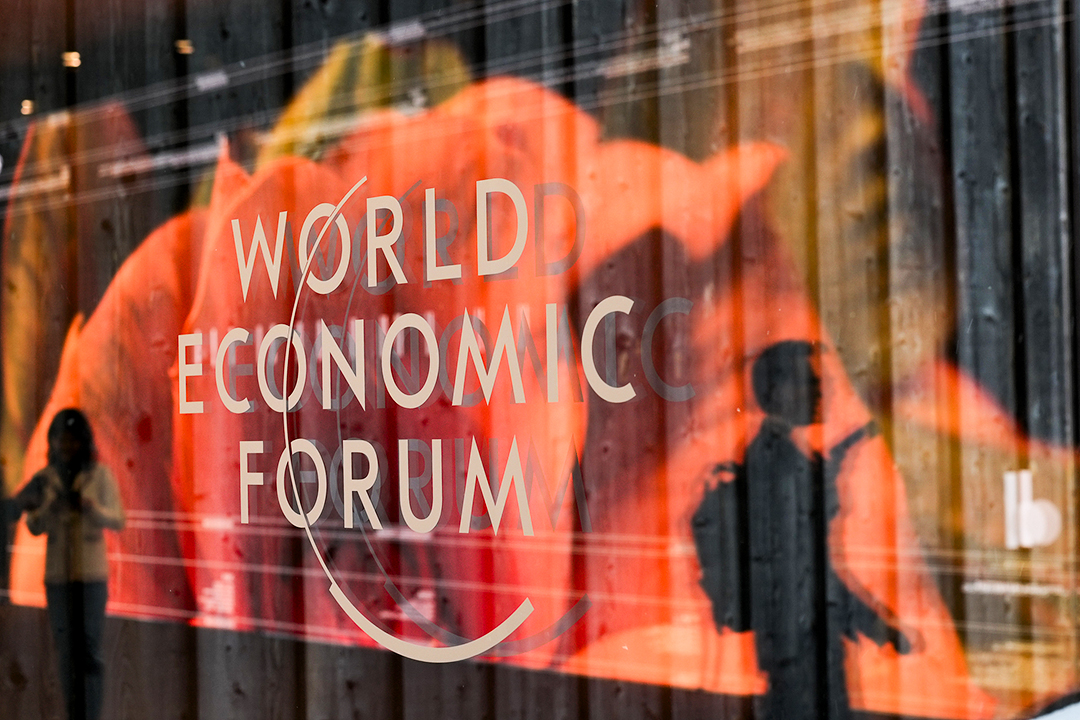 People are reflected in a window with the logo of the World Economy Forum on the last day of the forum's Annual Meeting in Davos, Switzerland on Jan. 19. Photo: VCG
